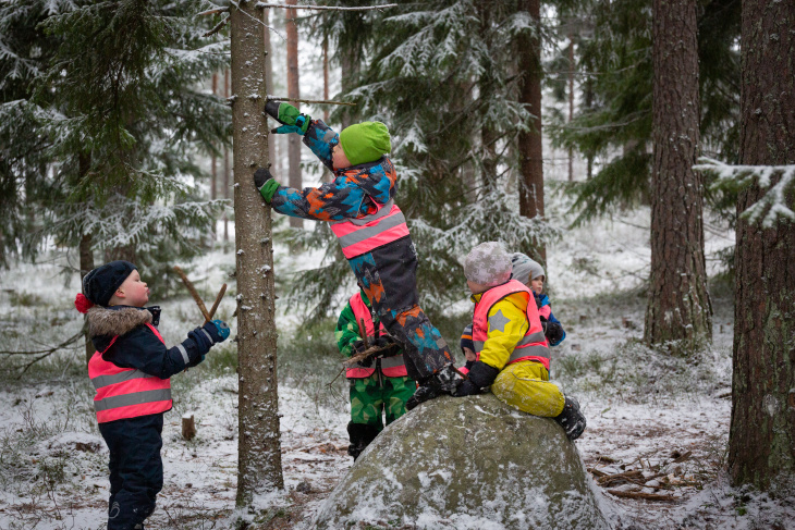 Lapset ulkoilemassa talvisessa metsässä