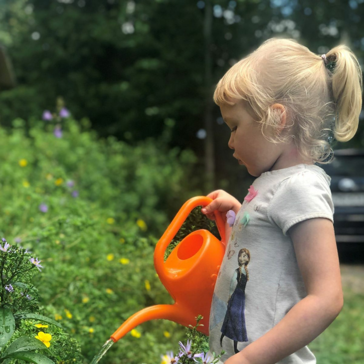 Lapsi kastelemassa kukkia kastelukannulla